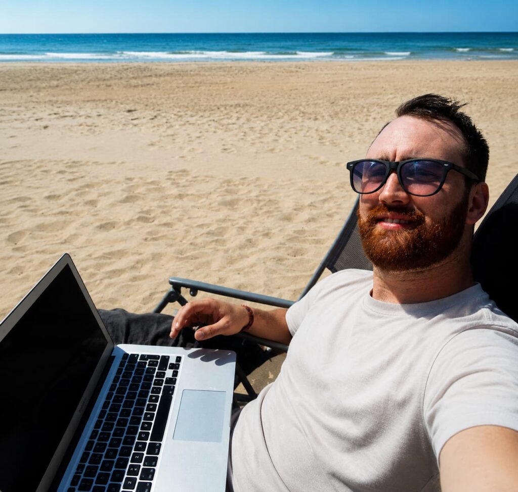 Robin Söderström arbetar med sin laptop vid stranden